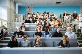 Абитуриенты и их родители слушают презентацию о программах высшего образования и специализированного высшего образования